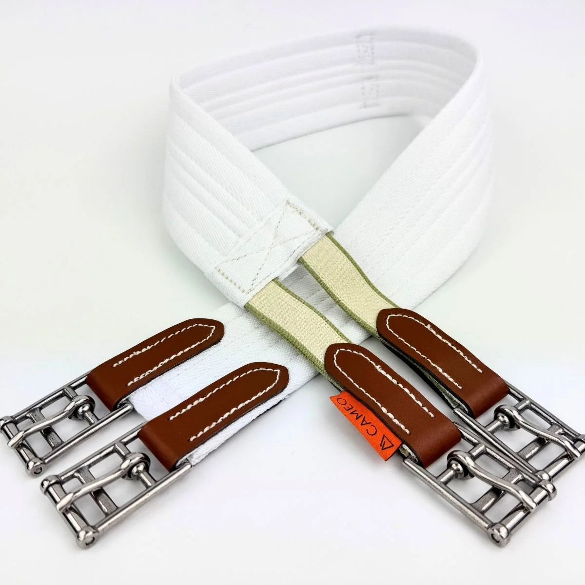 A white elastic belt with silver-tone buckle hardware, brown leather trim, and a small orange tag reading 'A CAMIE' on a clean white background.