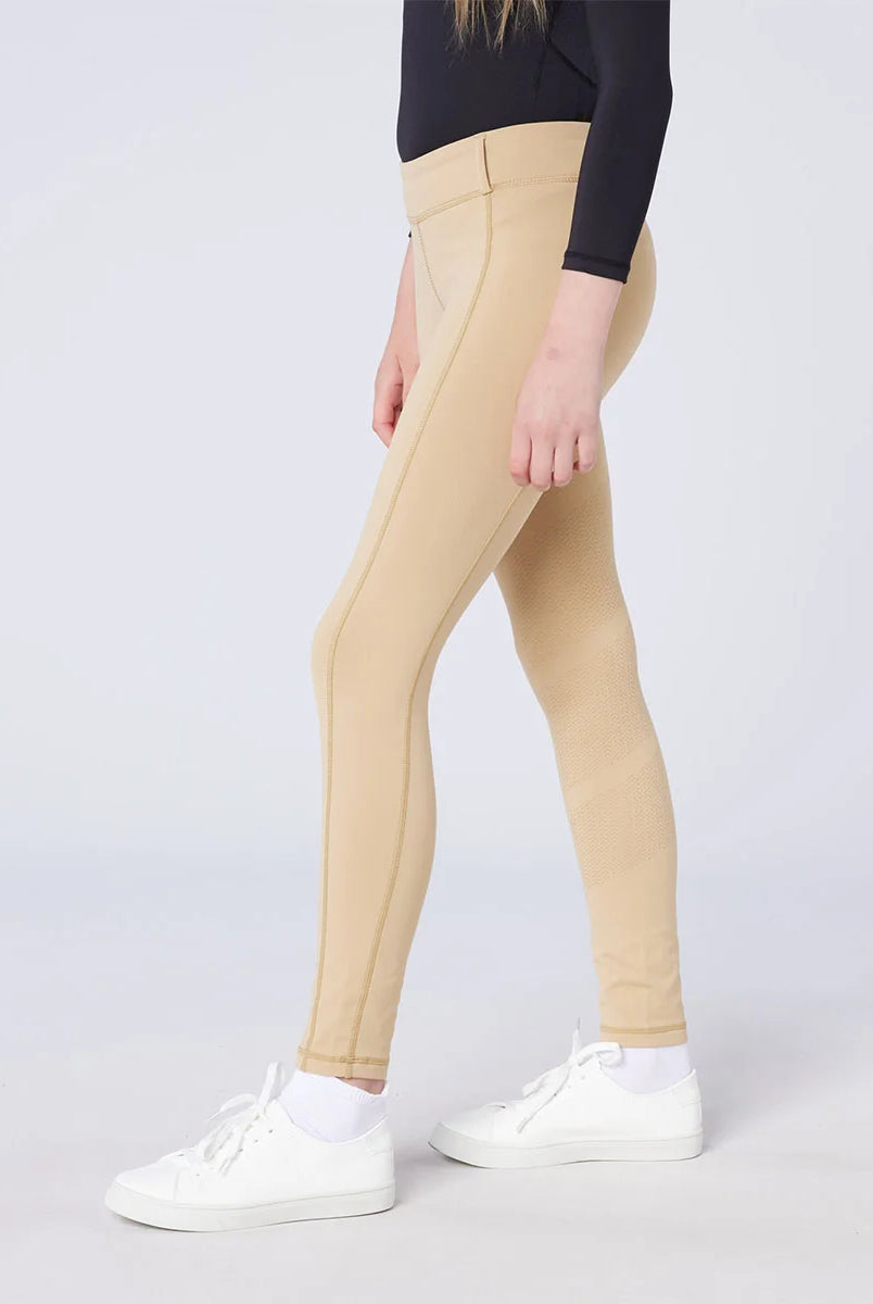 CAMEO All Season Riding Tights in Beige worn by a junior rider, featuring an innovative full-seat silicone chevron grip for elite in-saddle stability. These technical equestrian leggings provide 4-way compression stretch, a high-rise waistband, and a thermal brushed lining for all-weather riding.