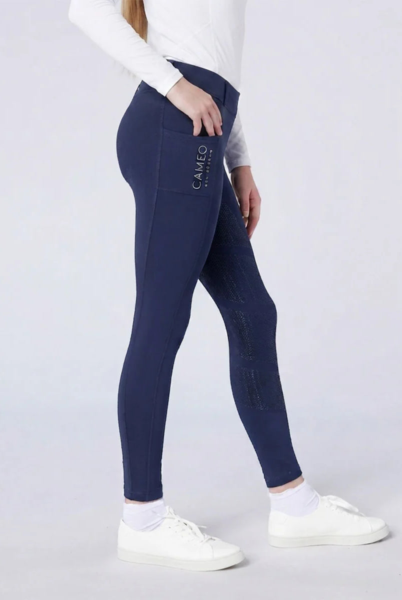 CAMEO All Season Riding Tights in Navy worn by a junior rider, featuring a deep ergonomic thigh smartphone pocket and a full-seat chevron silicone grip for maximum in-saddle security. These technical equestrian leggings include a thermal brushed lining and 4-way compression stretch for UK riders.