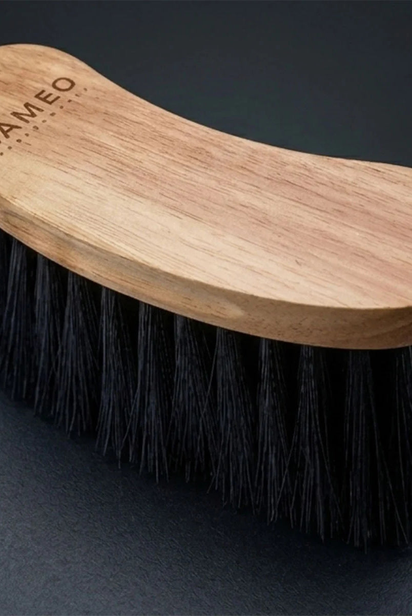 CAMEO Heritage Flick Brush in Natural Wood on a studio background featuring long, flexible bristles to flick away surface dirt.