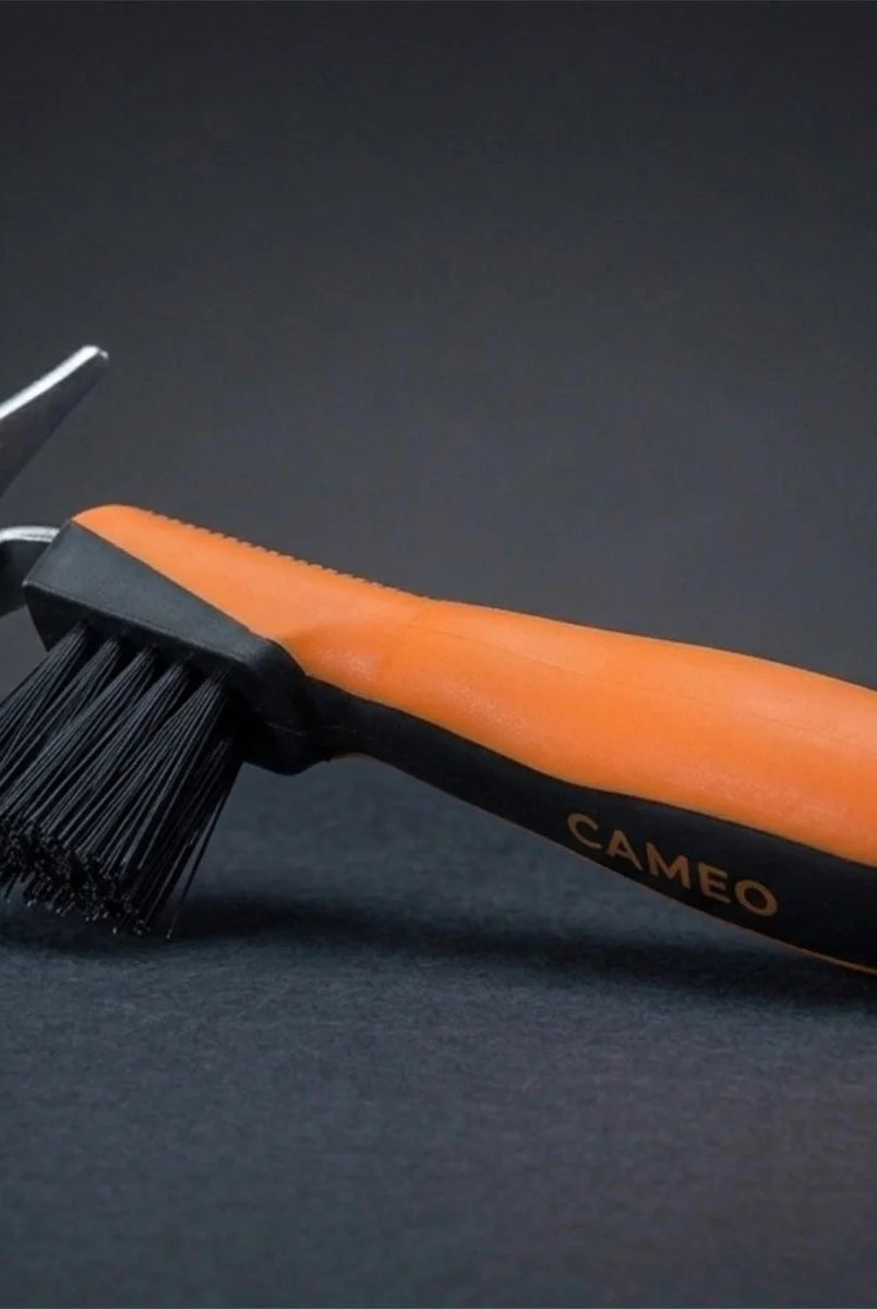 CAMEO Hoof Pick with Brush in Orange with an ergonomic grip handle and durable pick head on a studio background.