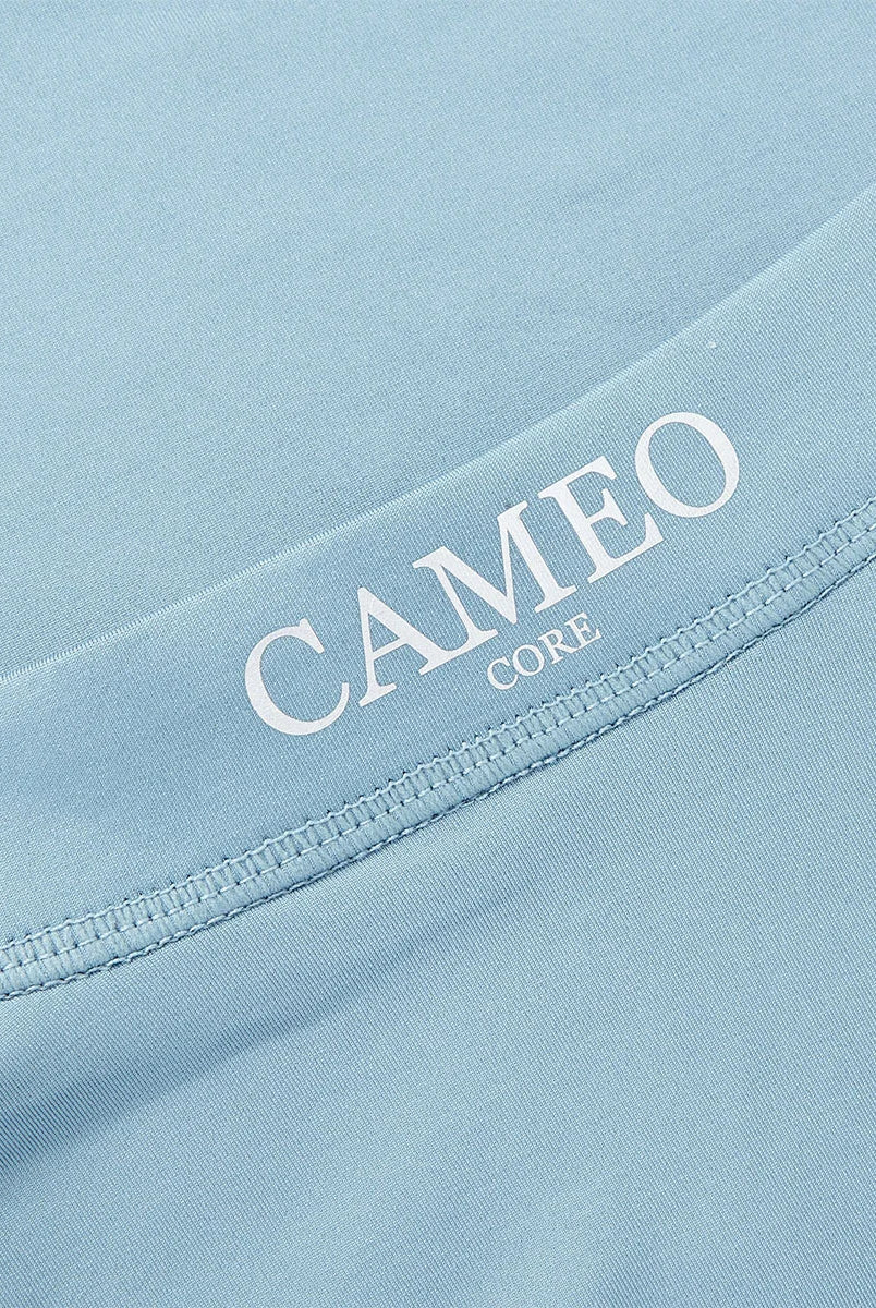 CAMEO Junior Core Baselayer in Cloud Blue showcasing the signature CAMEO CORE logo and precision flat-lock stitching. This close-up highlights the technical moisture-wicking CameoTech microfibre fabric designed to prevent chafing and regulate temperature for active young riders in the UK.