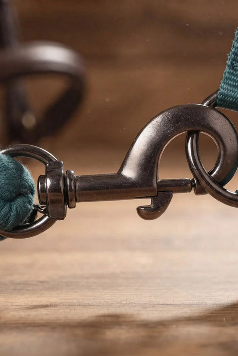 CAMEO Soft Polycotton Leadrope in EverGreen in a macro close-up, showcasing the Cacao bronze swivel trigger snap and twisted 3-strand weave clipped to a headcollar, engineered with soft cotton fibres for burn-free grip, tangle prevention, and dependable control during stableyard handling.