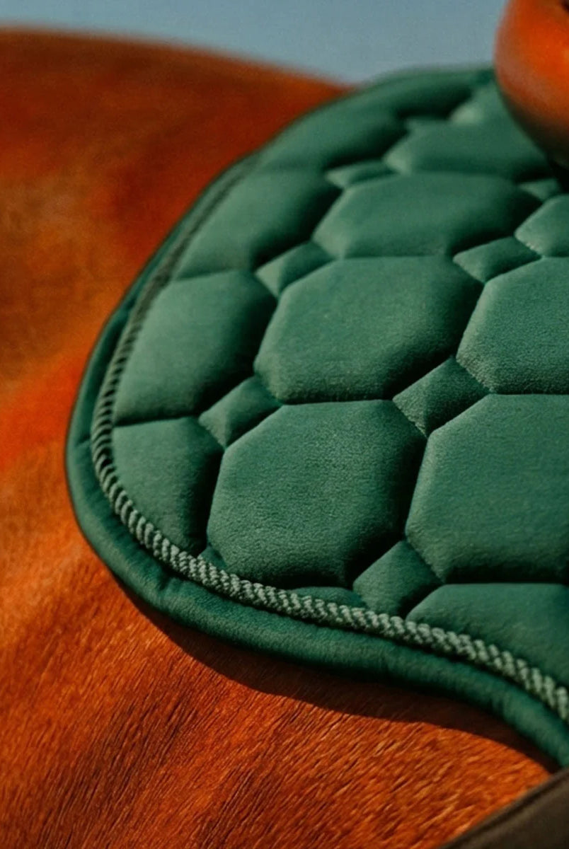 CAMEO Suede GP & Jump Saddlecloth in EverGreen in a macro close-up on a chestnut horse, showcasing the geometric quilted micro-suede, twisted rope binding, and shock-absorbing foam core engineered for spinal relief and jumping saddle comfort.