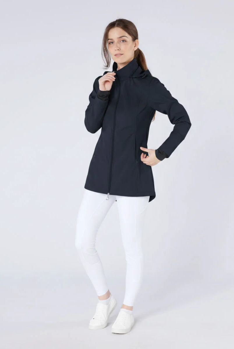 CAMEO Zenith Pro Ride Coat in Navy modelled on a studio model in white riding tights, showcasing the tailored longline waterproof cut, high storm collar, two-way stirrup zip, and thumb-loop cuffs engineered for cold-weather riding and yard duty comfort.