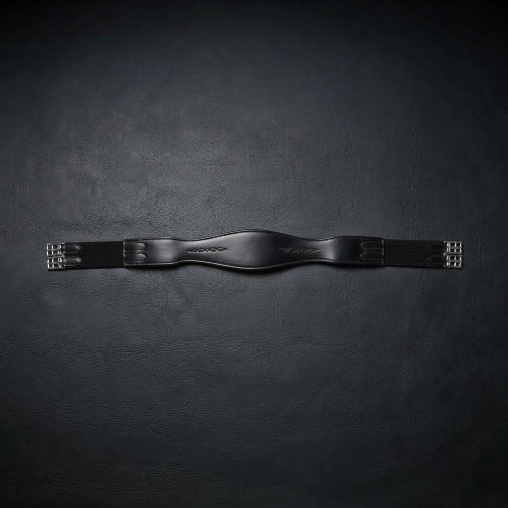 A black leather horse girth with silver metal buckles, displayed horizontally against a dark textured background.