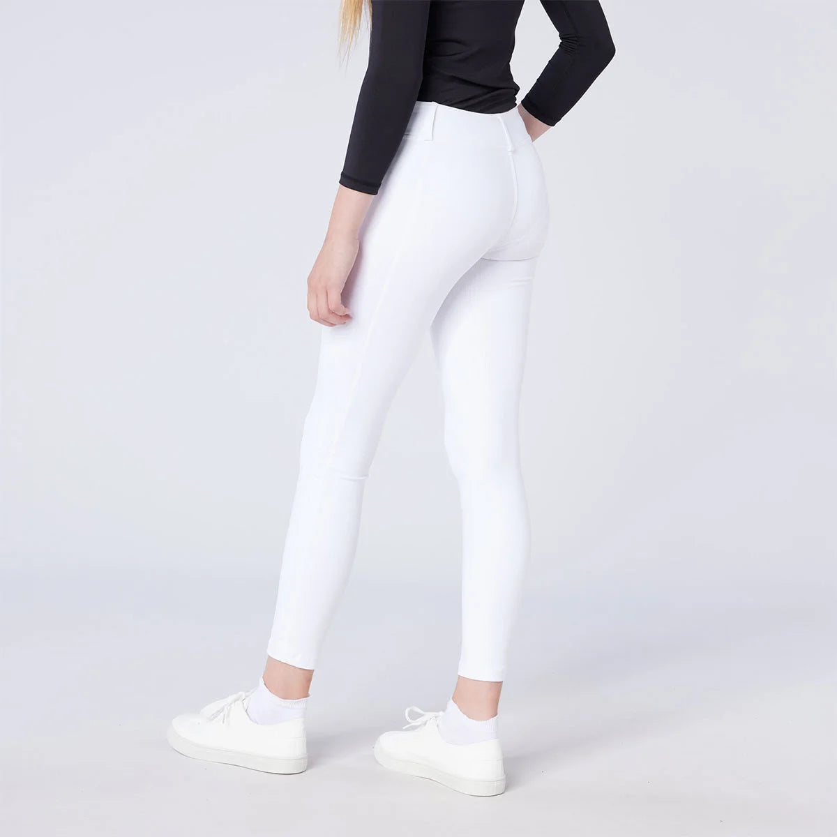 CAMEO All Season Riding Tights in White worn by a junior rider, featuring an innovative full-seat silicone chevron grip for maximum in-saddle security. These technical competition leggings include a high-rise core-supporting waistband and thermal brushed lining for professional show-day comfort.