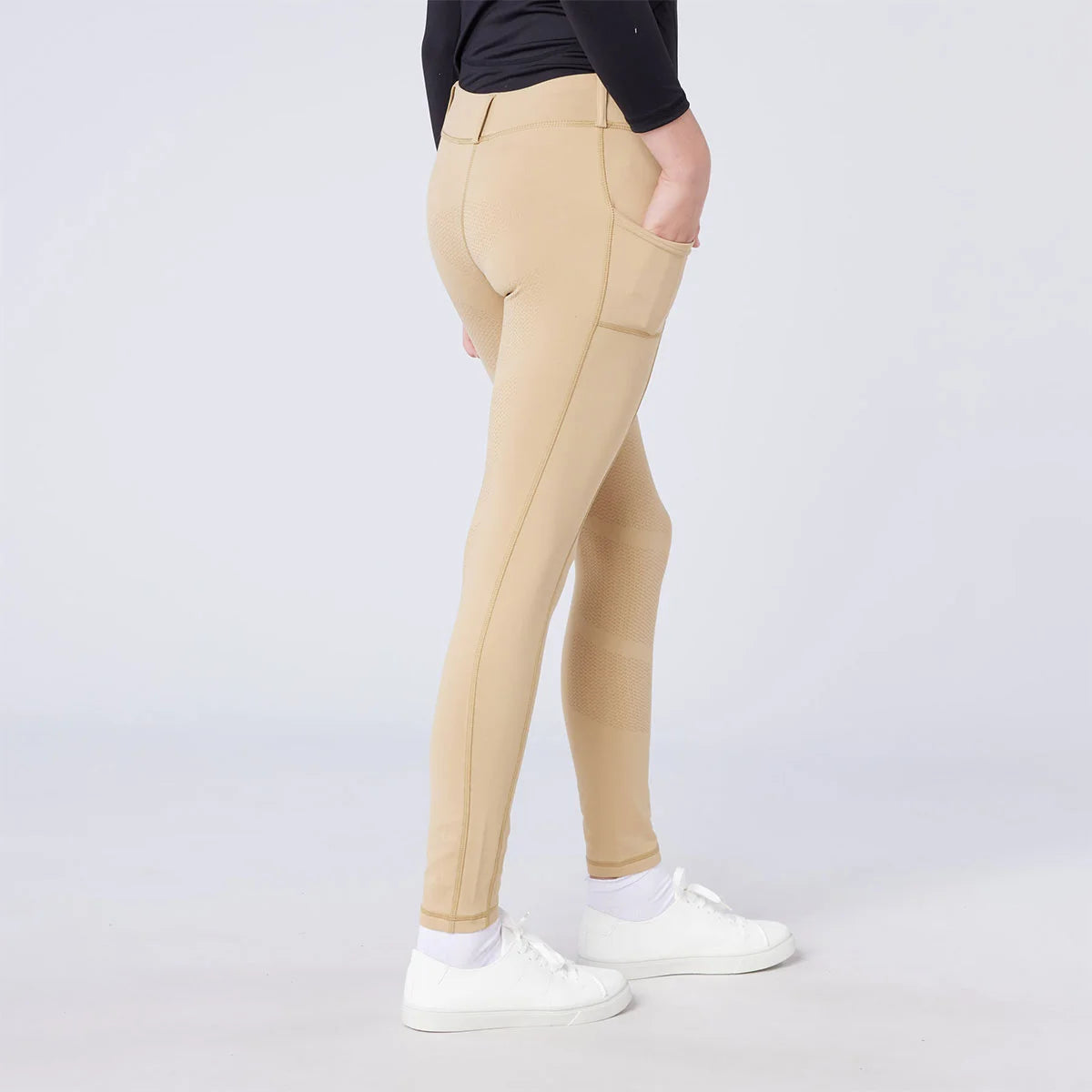 CAMEO All Season Riding Tights in Beige worn by a junior rider, featuring a deep ergonomic thigh smartphone pocket and a full-seat chevron silicone grip for superior in-saddle stability. These technical equestrian leggings include a thermal brushed lining and 4-way compression stretch for UK riders.
