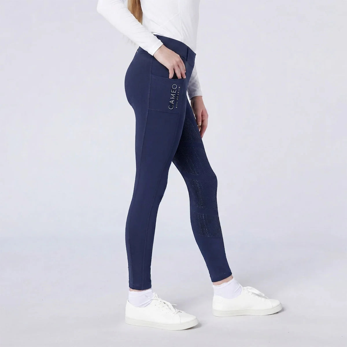 CAMEO All Season Riding Tights in Navy worn by a junior rider, featuring a deep ergonomic thigh smartphone pocket and a full-seat chevron silicone grip for maximum in-saddle security. These technical equestrian leggings include a thermal brushed lining and 4-way compression stretch for UK riders.