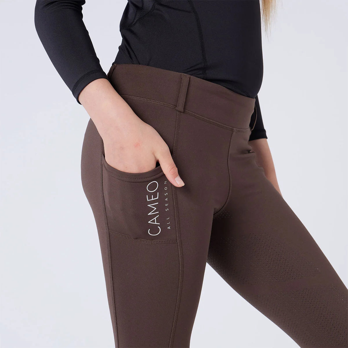 CAMEO All Season Riding Tights in Chocolate Brown featuring a deep ergonomic drop-in smartphone pocket and reflective branding. This close-up highlights the high-rise compressive waistband, reinforced belt loops, and technical 4-way stretch fabric engineered for athletic performance and yard durability.