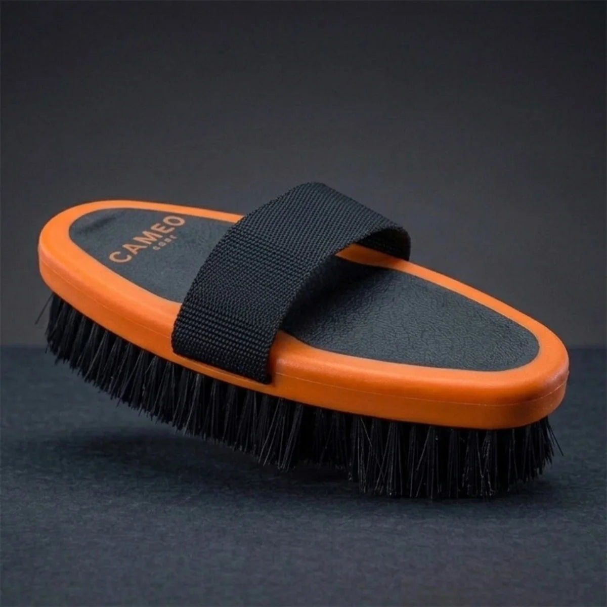 CAMEO Body Brush in Orange on a studio background highlighting the ergonomic oval block and uniform bristle trim.
