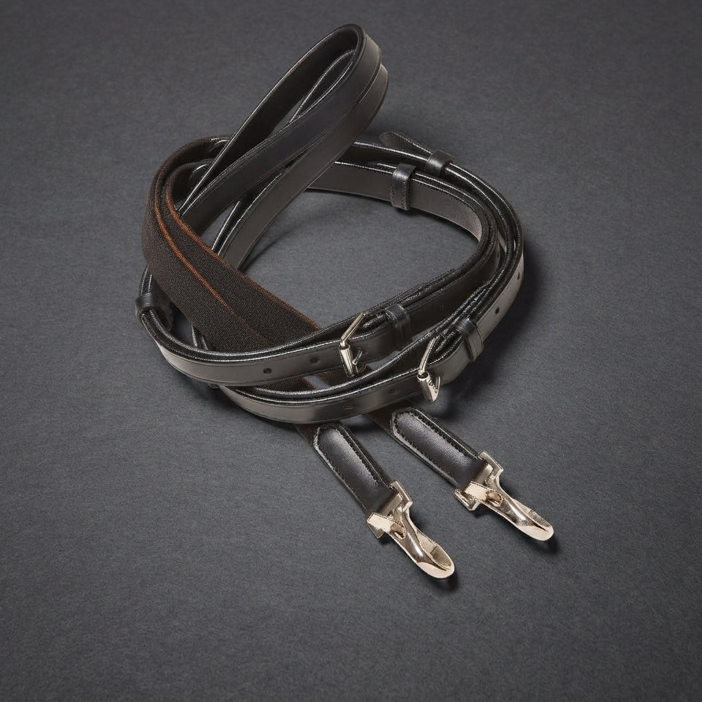 A dark brown leather side rein strap with silver metal buckles and clips, coiled on a dark gray textured background.