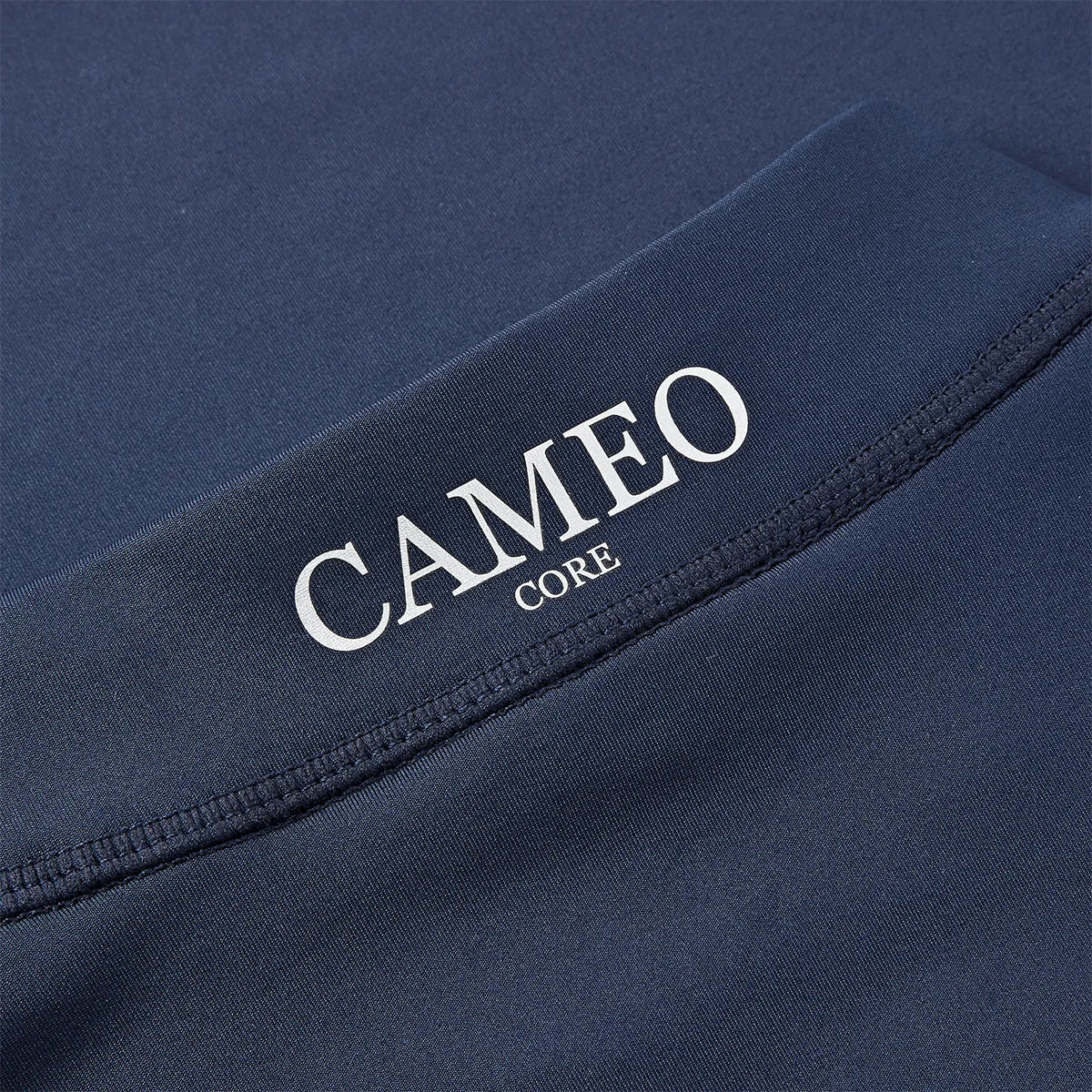 CAMEO Core Collection Baselayer in Navy showing a macro close-up of the reflective silver CAMEO CORE branding and premium anti-chafing flat-lock seams. This technical detail highlights the high-performance CameoTech 4-way stretch fabric designed for superior equestrian comfort and durability.