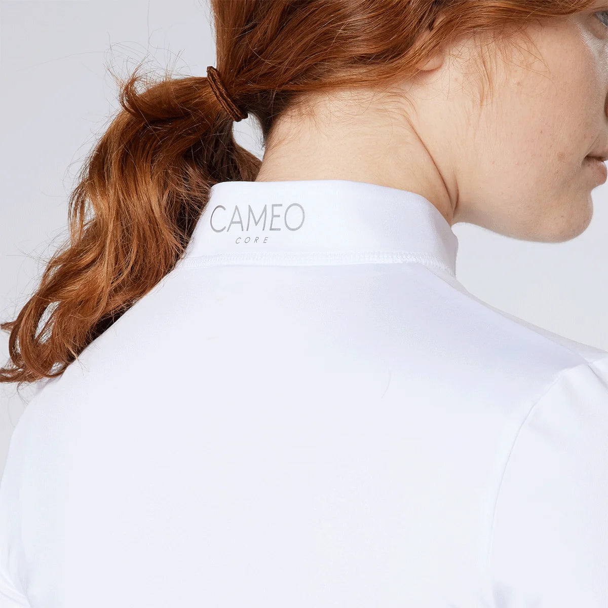 CAMEO Core Collection Baselayer in White showing the reflective silver CAMEO CORE branding on the rear stand collar. This close-up highlights the high-quality technical microfibre fabric and precision flat-lock stitching designed for professional equestrian competition and training comfort.