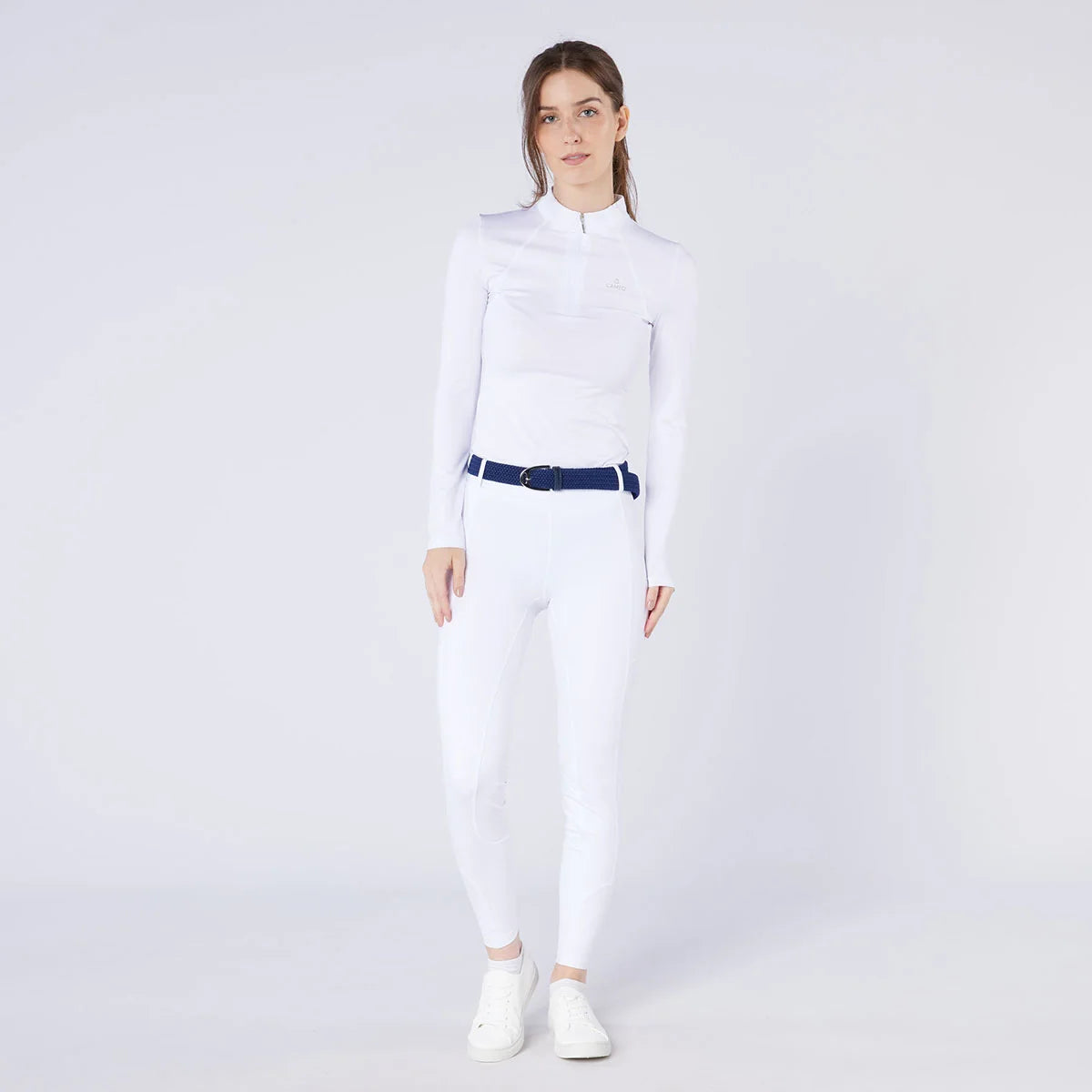 CAMEO Core Woven Stretch Belt in Navy modelled on an equestrian in white competition breeches, showcasing the holeless braided elastic webbing, stirrup buckle, and leather chapes engineered for infinite micro-adjustability and non-restrictive comfort.