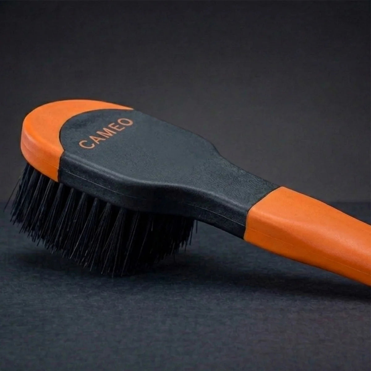 CAMEO Ergonomic Bucket Brush in Orange on a studio background featuring dense curved bristles for scrubbing stable feed buckets.