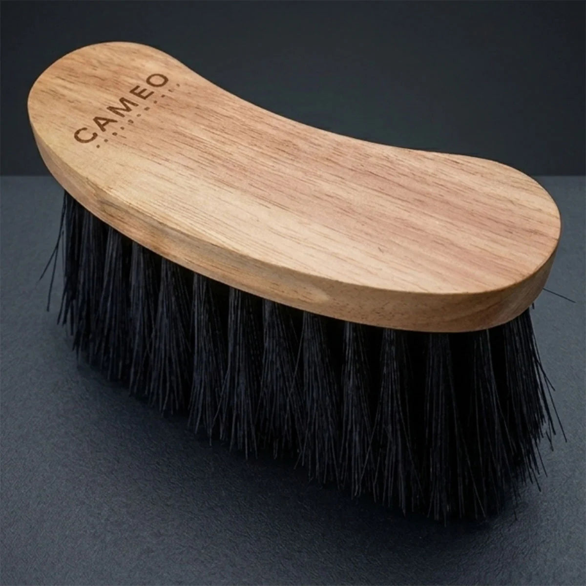 CAMEO Heritage Flick Brush in Natural Wood on a studio background featuring long, flexible bristles to flick away surface dirt.