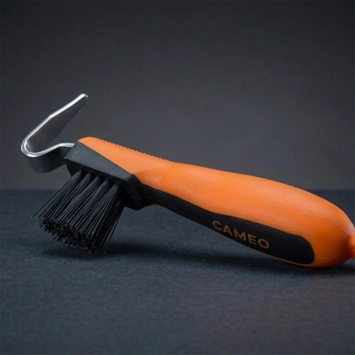 CAMEO Hoof Pick with Brush in Orange with an ergonomic grip handle and durable pick head on a studio background.