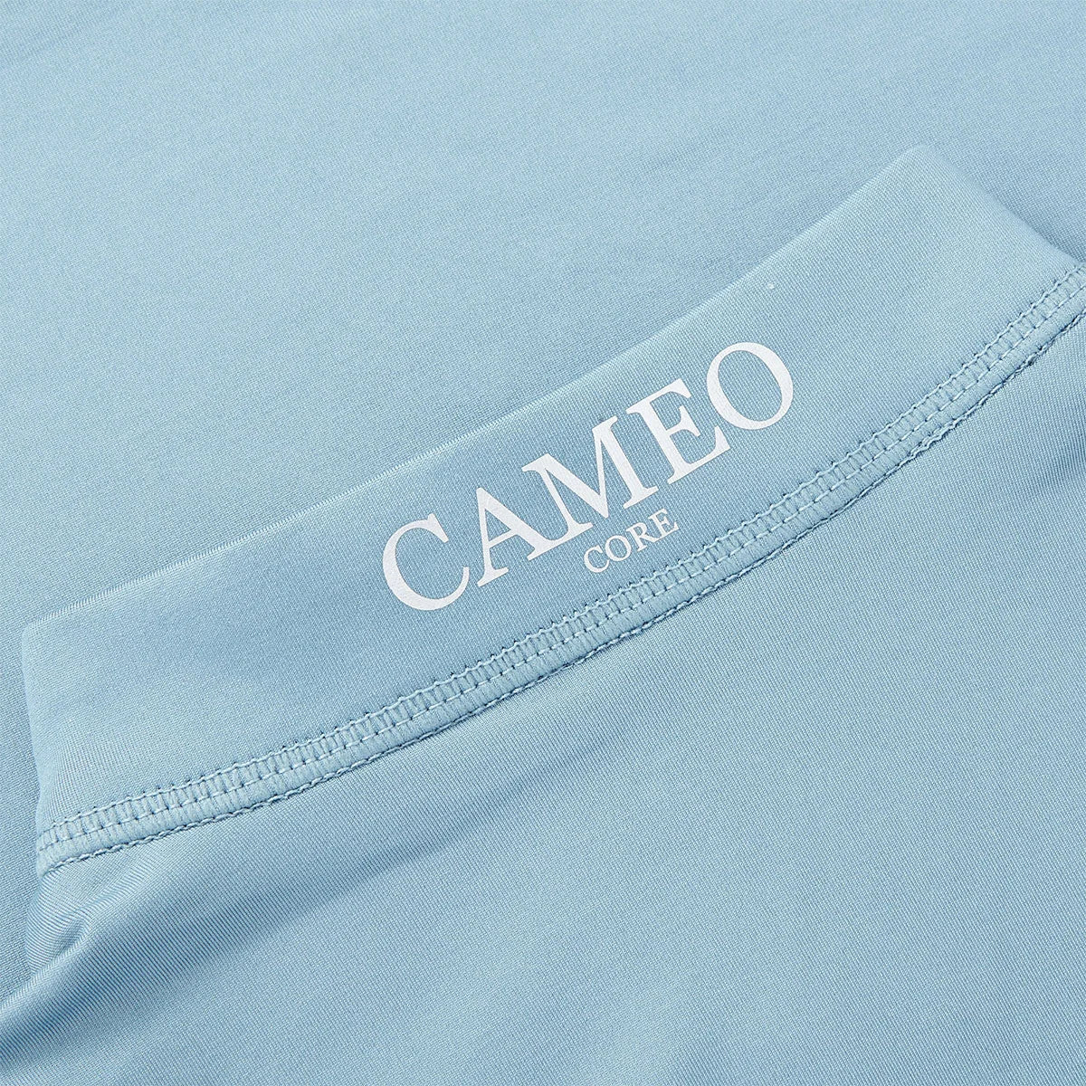 CAMEO Junior Core Baselayer in Cloud Blue showcasing the signature CAMEO CORE logo and precision flat-lock stitching. This close-up highlights the technical moisture-wicking CameoTech microfibre fabric designed to prevent chafing and regulate temperature for active young riders in the UK.