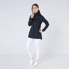 CAMEO Zenith Pro Ride Coat in Navy modelled on a studio model in white riding tights, showcasing the tailored longline waterproof cut, high storm collar, two-way stirrup zip, and thumb-loop cuffs engineered for cold-weather riding and yard duty comfort.