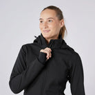 CAMEO Zenith Pro Ride Coat in Black modelled on a female equestrian, showcasing the high fleece-lined storm collar, stretch thumb-loop cuffs, detachable hood, and tonal logo engineered for windproof warmth and foul-weather riding comfort.